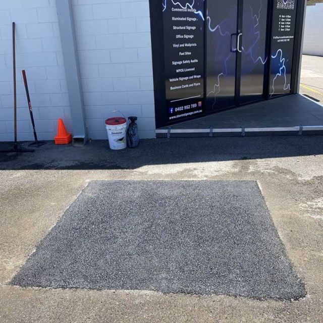 Completed asphalt patch repair at commercial site with new smooth surface installed