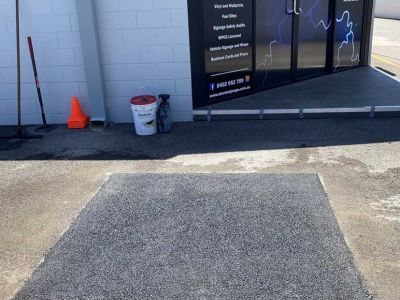Completed asphalt patch repair at commercial site with new smooth surface installed