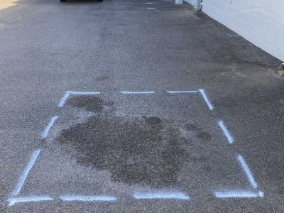 Commercial pavement marked out for asphalt patch repair with damaged surface visible